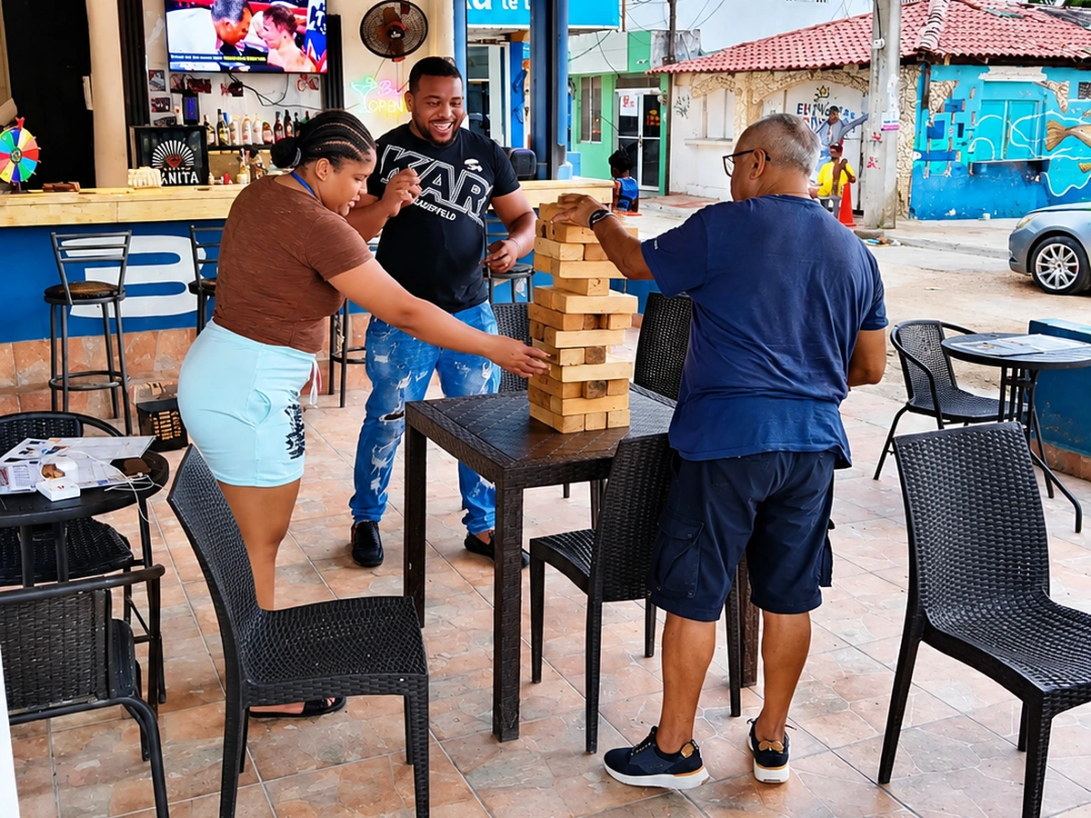Friends playing giant Jenga at a patio table at 365 Beach Bar