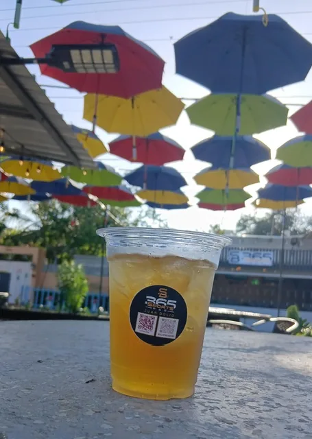 A cold 365 drink on the patio under the umbrellas in daylight